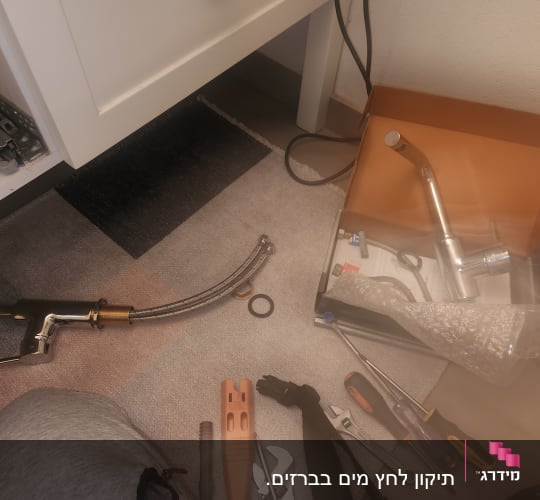 כלים וחלקי ברז על הרצפה